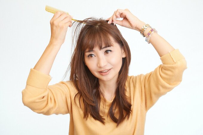 分け目をスタイリングしている女性