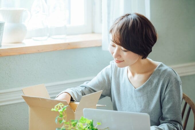 段ボールを開ける女性