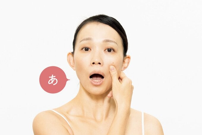 頬骨をつまみ「あ」の口の動きをする女性