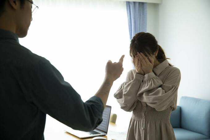 顔をおさえる女性と指差し男性