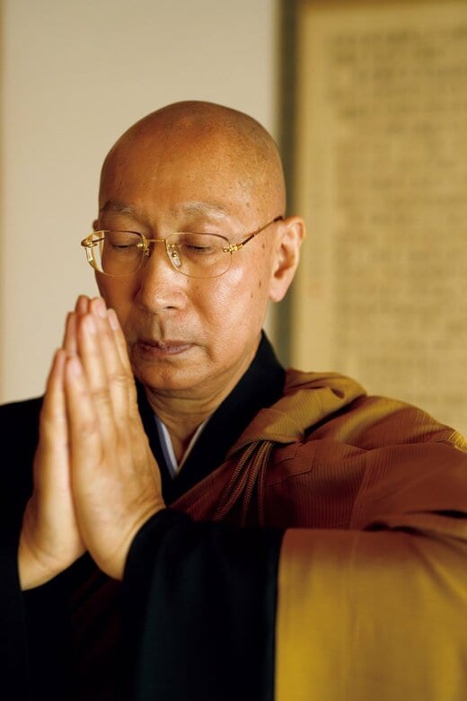 手を合わせている住職