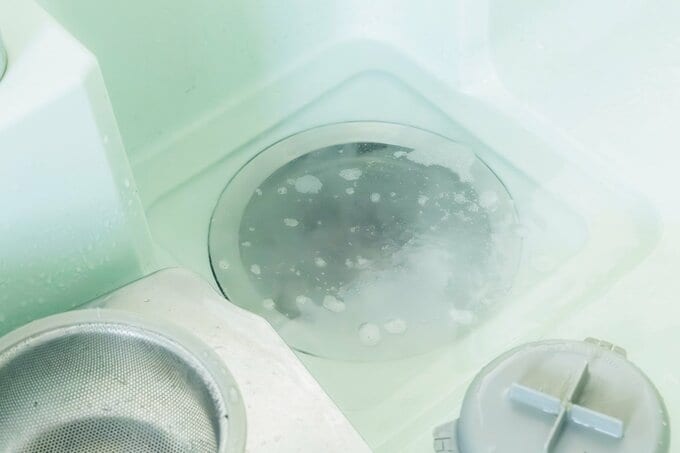 排水溝を過炭酸ナトリウムで掃除をしている様子