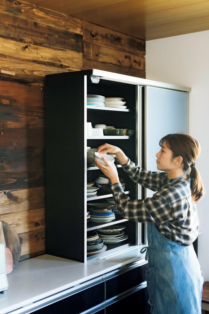 カップボードから食器を取り出すSHINOさん