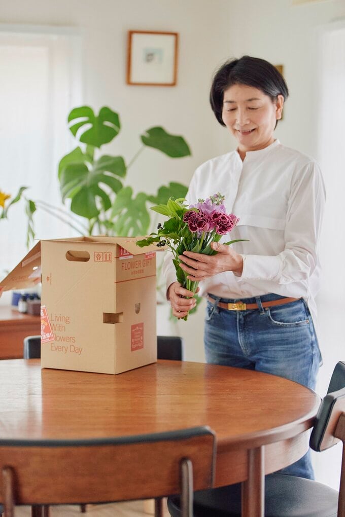 届いた花を持つ女性