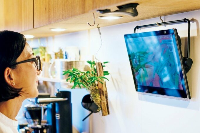 ポータブルテレビを見る女性