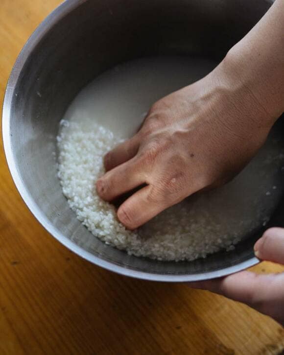 ボウルにお米と水を入れて混ぜる