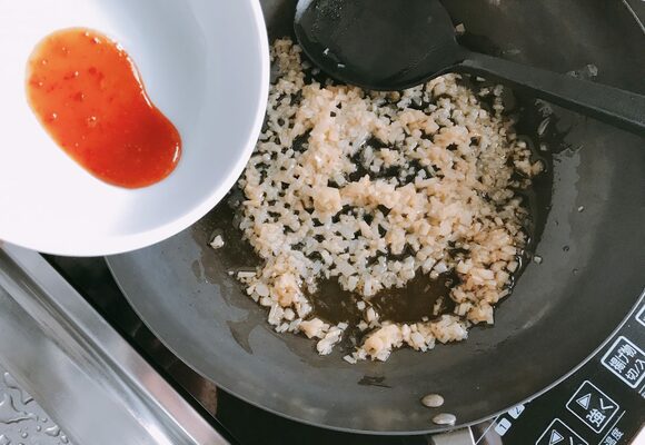 香りが立って薄く色づいたら、火からおろして豆板醤を加えてひと炒めする。