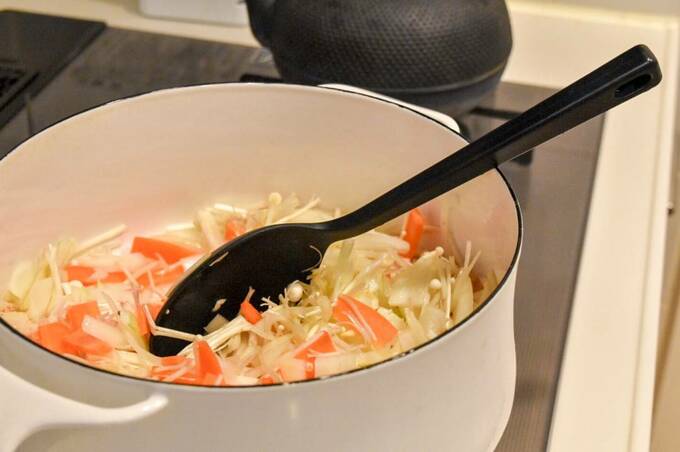 鍋にキノコなどの食材とシリコン調理スプーン
