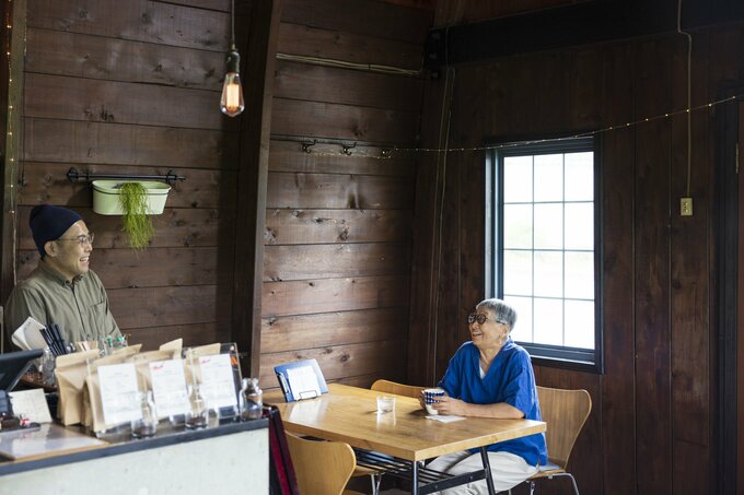 喫茶店の店主と話す徳田民子さん