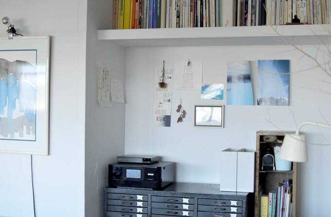 コピー機の近くの壁にポストカードなど