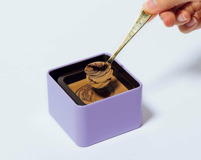 紫色の缶からチョコをすくう様子