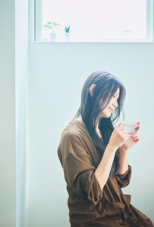 カップを手に持ち横を向く女性