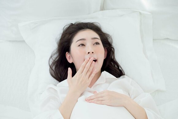 お布団で眠そうな女性