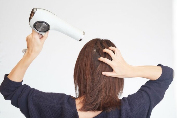 ドライヤーをする女性