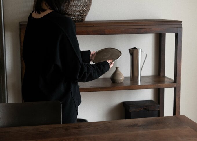 トレーを手に取り眺める女性