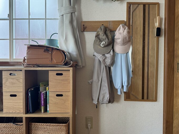 子どもの学用品と上着を近くに置いた収納