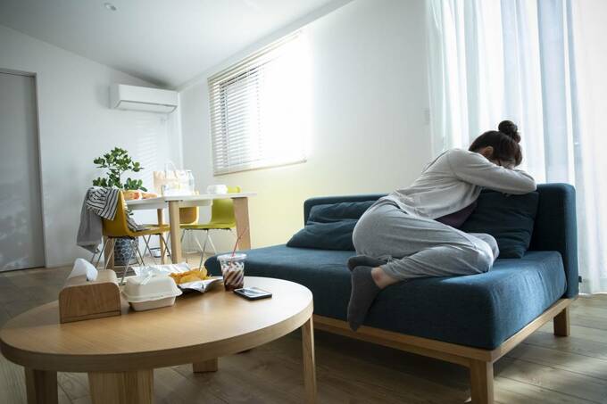 ソファでうずくまる女性