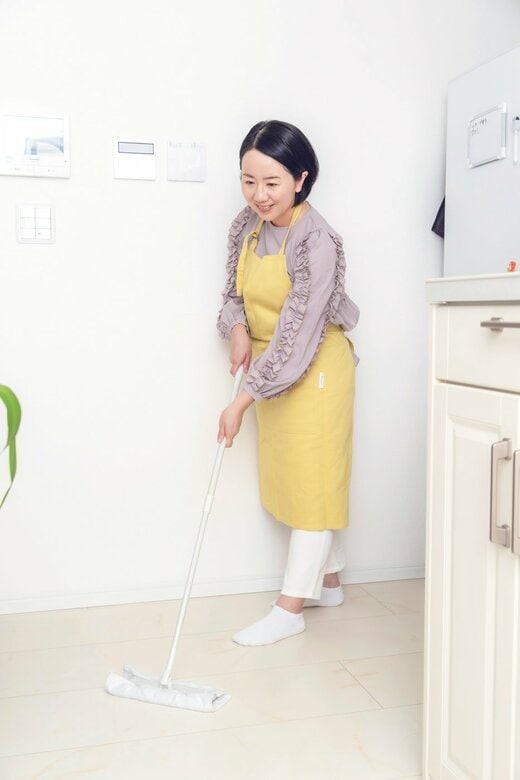 フロアワイパーで床を掃除する女性