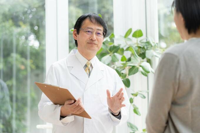 バインダーを持つ白衣の男性