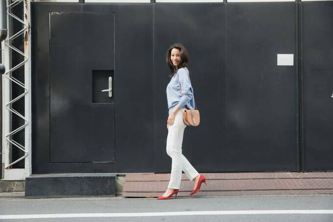 黒い壁の前で歩く女性