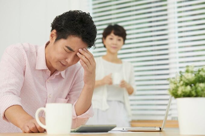 イライラしている夫を見る妻