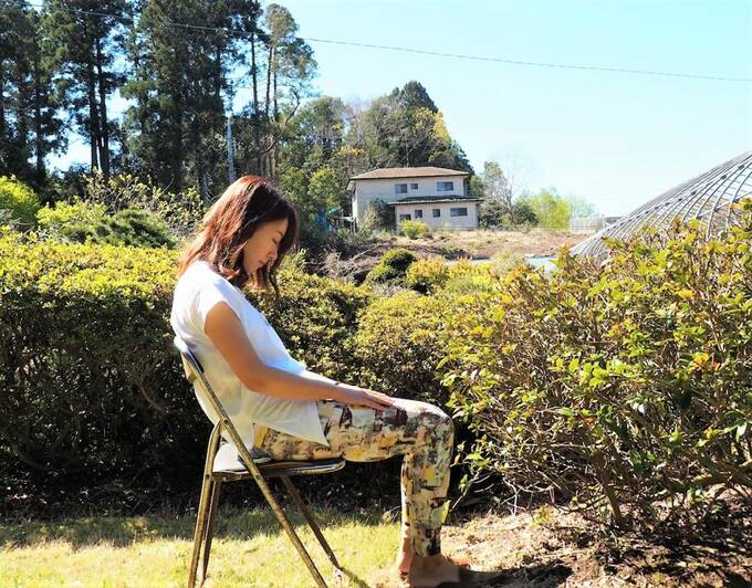 イスに座って下を向く女性