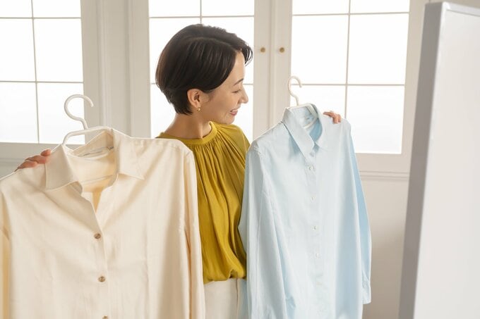 シャツを体にあてる女性