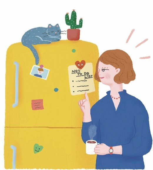 冷蔵庫に貼ったリストを見る女性