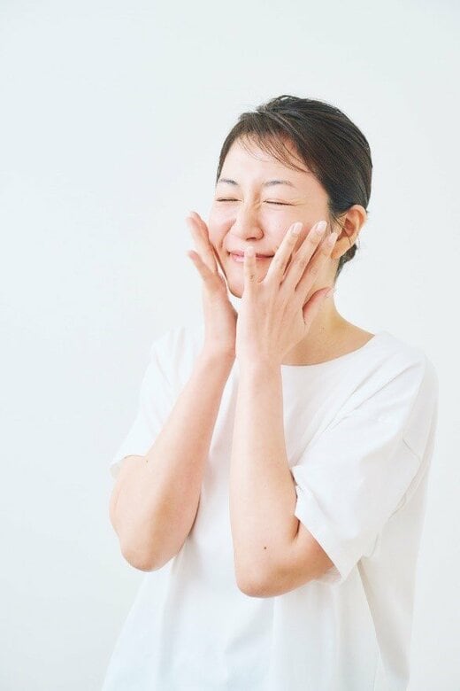 手を両頬にあてる女性