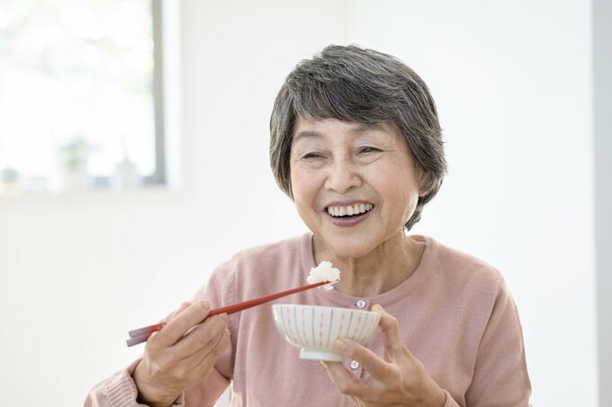 笑顔で食事をするシニア女性