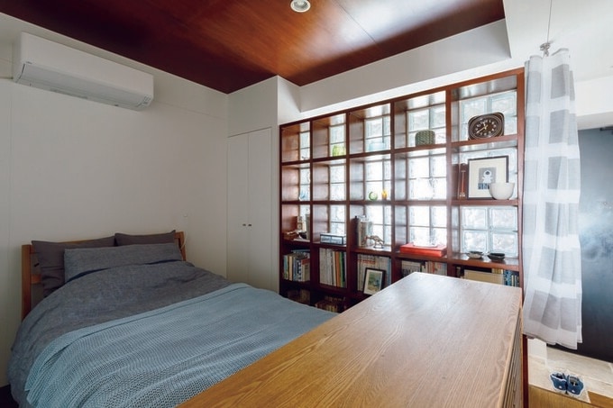 シェルフとガラスブロックで仕切られた寝室