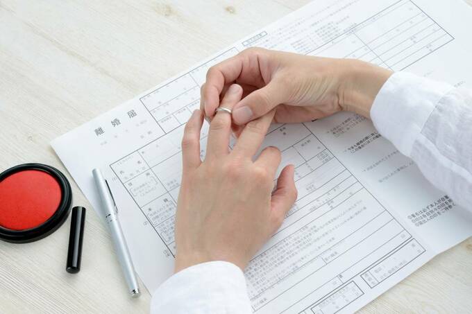 離婚届の上で指輪を外す様子