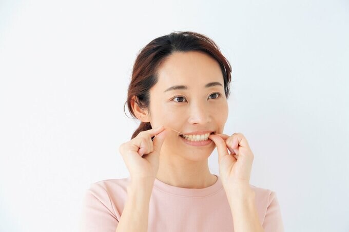 フロスを使って歯間ケアをする女性