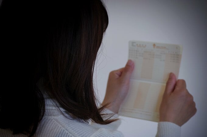 通帳を見る女性