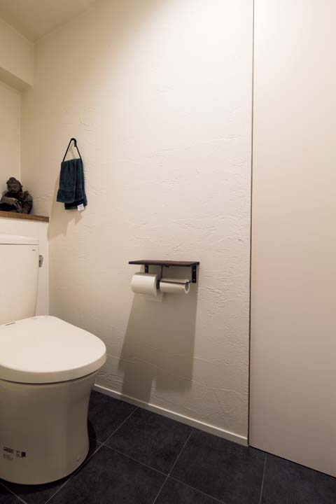 漆喰とタイルでシンプルな内装に仕上げたトイレ