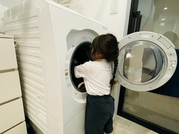 洗濯物を洗濯機に入れている様子