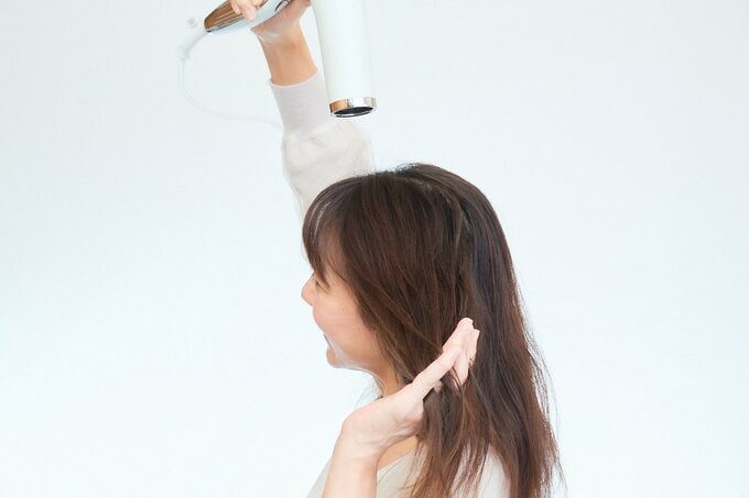 ドライヤーをする女性
