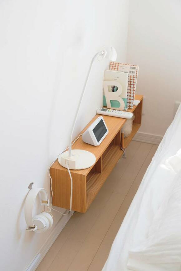 壁づけ家具に目覚まし時計や照明や本など
