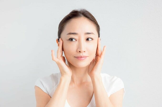 両指で耳の前をマッサージ