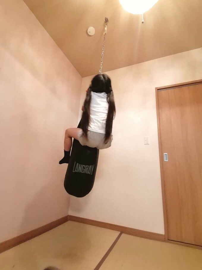 サンドバッグに抱き着く子ども