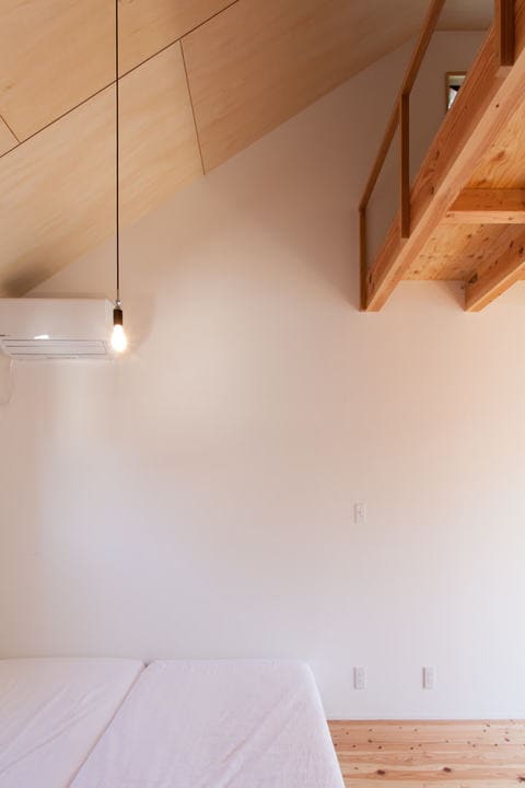 2階の勾配天井全面にシナ合板を貼った寝室