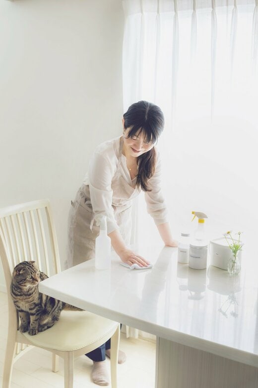 白い机を拭く女性
