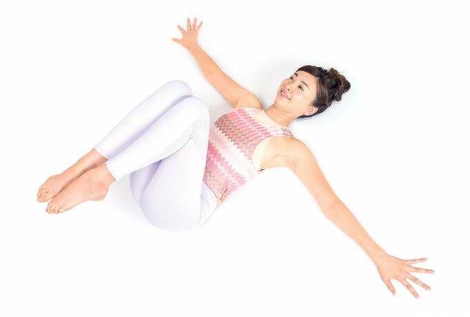 手を広げて床にあおむけになる女性