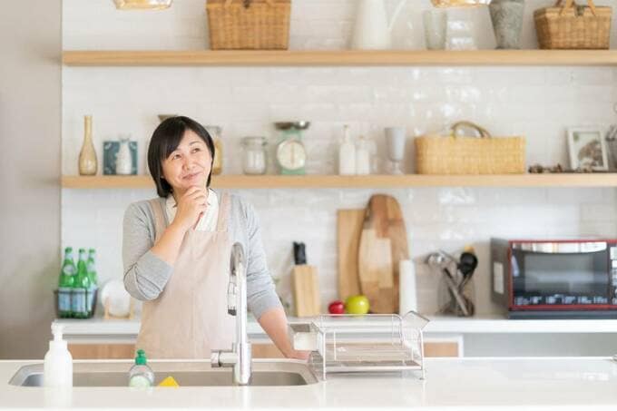 キッチンで考えている女性