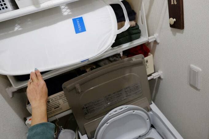 洗濯機の上からバスケットを取り出す様子