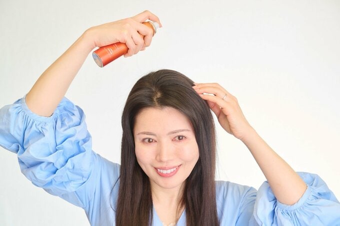 頭皮をスプレーする女性