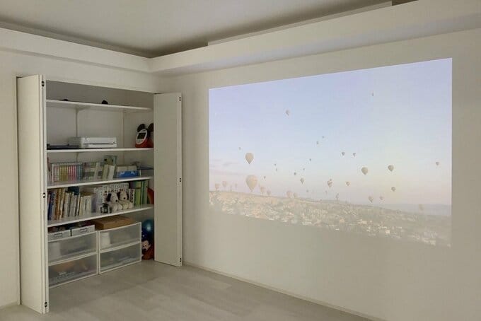 空のプロジェクションマッピングが投影されている壁とウォークイン収納