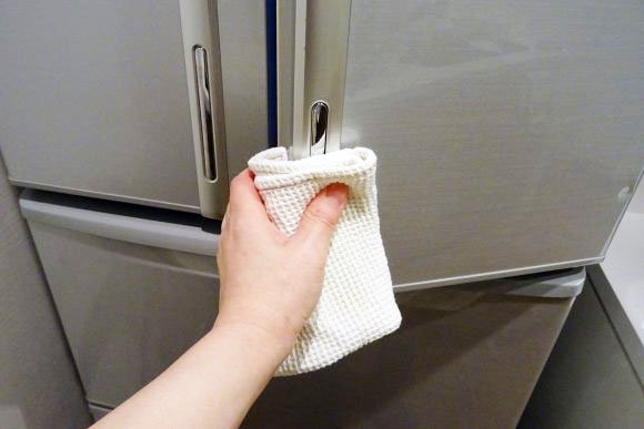 濡れた布巾を持って冷蔵庫の開閉