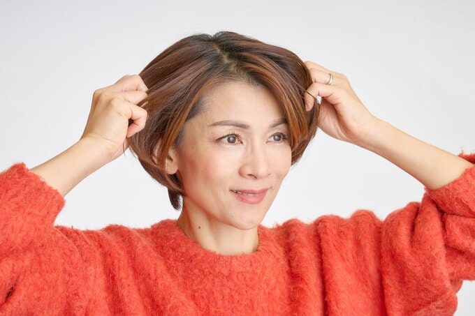 毛先にオイルをつける女性