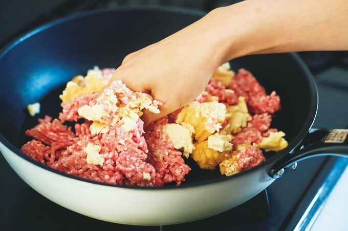 フライパンでひき肉をこねている様子
